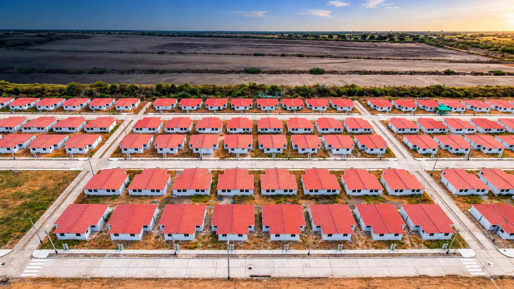 Vista aérea de un proyecto de vivienda con casas de techo rojo desarrollado por Premier Constructores